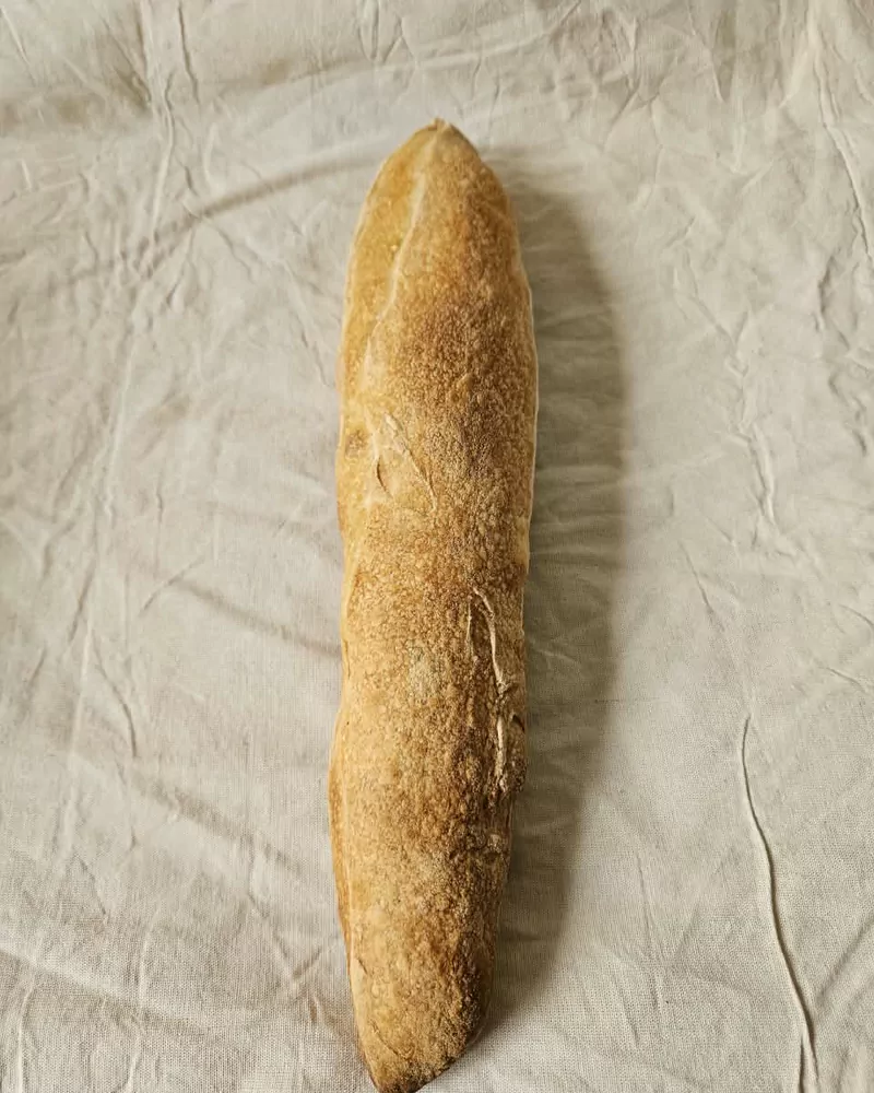 Baguette artesanal con corteza dorada sobre lino crudo, Bona Biga Pan Mendoza