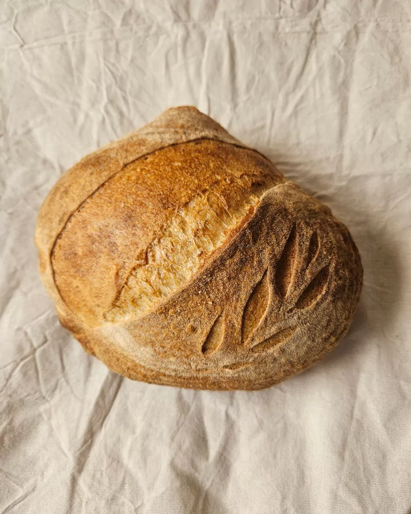 Hogaza de pan de campo con greñado artesanal sobre lino crudo, Bona Biga Pan Mendoza